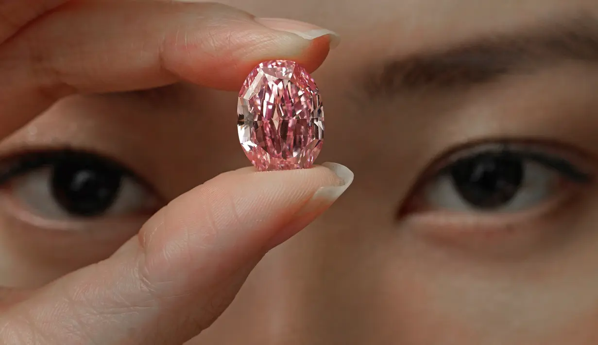 Model memperlihatkan berlian berwarna purple pink yang sangat langka di ruang lelang Sotheby Hong Kong pada 12 Oktober 2020. Rumah lelang Sotheby mengungkapkan, berlian itu diperkirakan akan terjual hingga 38 juta dolar AS (atau sekitar Rp 561 miliar). (AP Photo/Vincent Yu)
