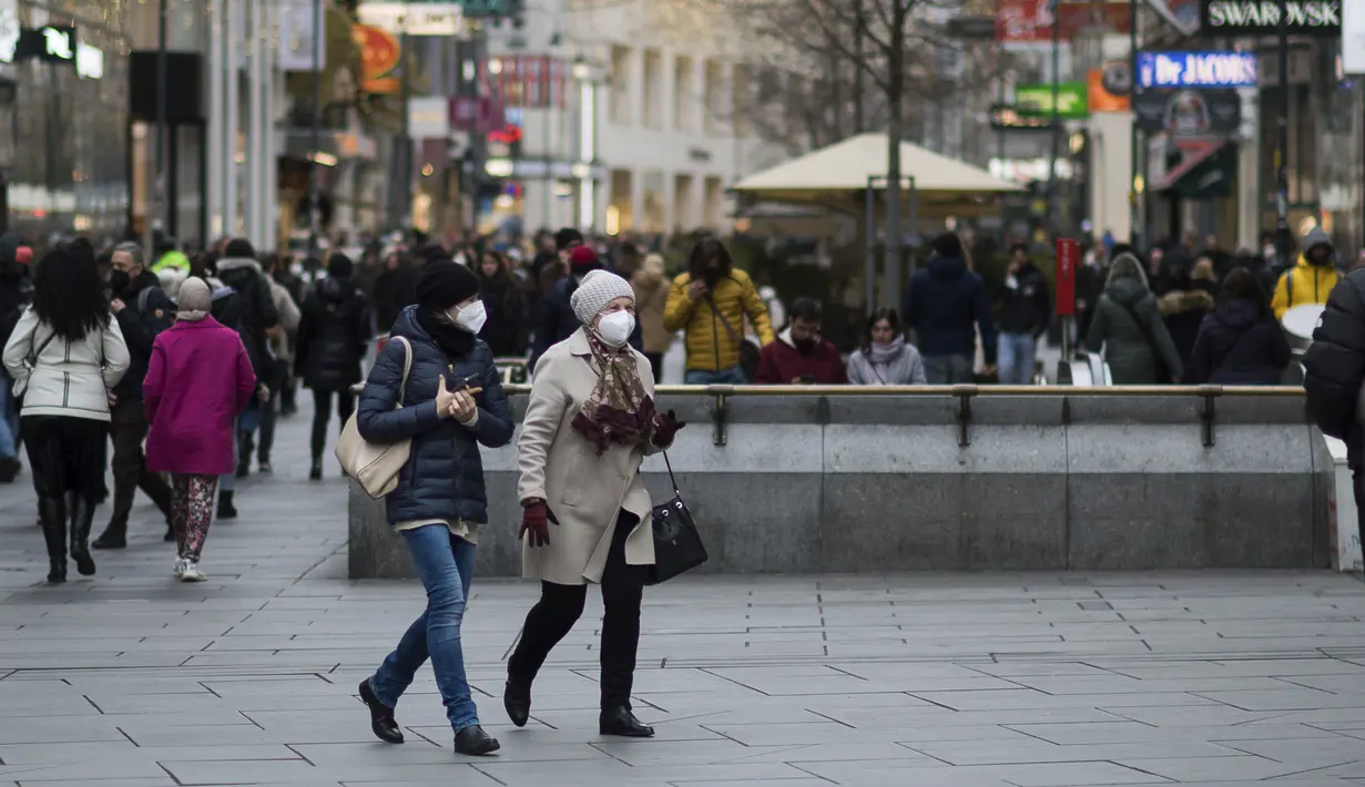 Orang-orang memakai masker saat mereka berjalan di jalan perbelanjaan di Wina, Austria, Rabu (17/11/2021).  Pemerintah Austria menetapkan penguncian nasional atau lockdown bagi warga yang tidak atau belum divaksinasi Covid-19. (AP Photo/Michael Gruber)