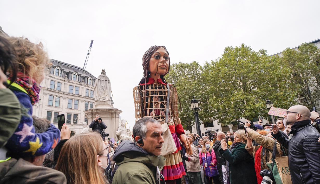 Boneka raksasa Little Amal tiba di Katedral St Paul, di London, Inggris, Sabtu (23/10/2021). Little Amal akan melanjutkan perjalanan ke kota Manchester di kawasan Inggris yang akan menjadi pemberhentian terakhirnya. (AP Photo/Alberto Pezzali)