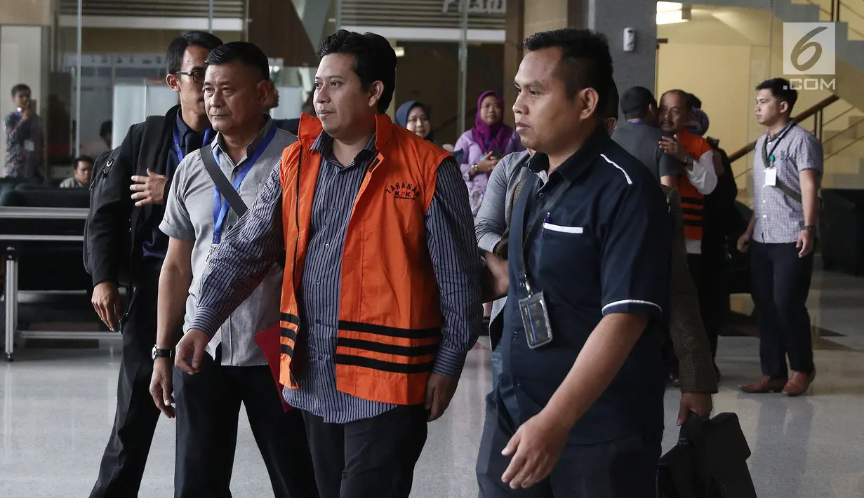 Bupati Cianjur Irvan Rivano Muchtar dikawal petugas usai menjalani pemeriksaan KPK, Jakarta, Kamis (13/12). Irvan dan Cecep Sobandi bersama Kepala Bidang SMP di Dinas Pendidikan Kab Cianjur Rosidin terjaring OTT KPK. (Liputan6.com/Herman Zakharia)