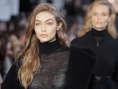 Supermodel Gigi Hadid berjalan di atas catwalk mengenakan busana karya Max Mara selama Autumn / Winter 2017 di Milan Fashion Week, Italia (23/2). Gigi Hadid tampil cantik dan seksi dengan busana tipis berwarna hitam. (AP Photo / Luca Bruno)