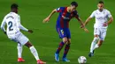 Pemain Barcelona Sergio Busquets (tengah) memperebutkan bola dengan pemain Huesca Idrissa Doumbia (kiri) dan David Ferreiro (kanan) pada pertandingan Liga Spanyol di Stadion Camp Nou, Barcelona, Spanyol, Senin (15/3/2021). Barcelona menang 4-1. (AP Photo/Joan Monfort)