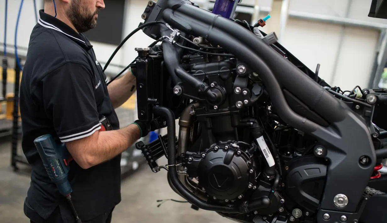 Pekerja  merakit sepeda motor Triumph di jalur perakitan di pabrik Triumph Motorcycles di Hinckley, Inggris (2/10). Awalnya Triumph dibentuk sebagai perusahaan manufaktur sepeda di Coventry pada tahun 1887. (AFP Photo/Oli Scarff)
