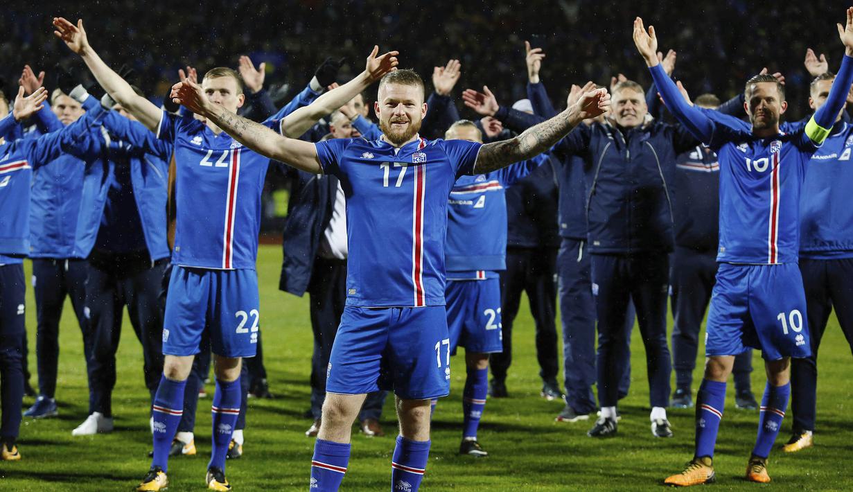 Kapten Islandia, Aron Gunnarsson, bersama rekan- rekannya melakukan selebrasi usai memastikan negaranya lolos Piala Dunia 2018 di Stadion Laugardalsvöllur, Senin (9/10/2017). Islandia menang 2-0 atas Kosovo. (AP/Brynjar Gunnarsson)