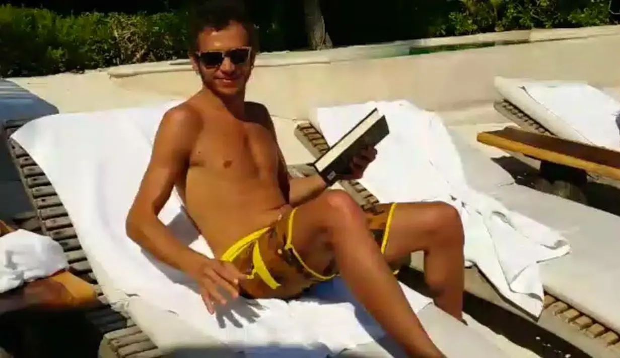 Valentino Rossi berjemur sambil membaca buku di salah satu pantai di Meksiko. (Facebook)