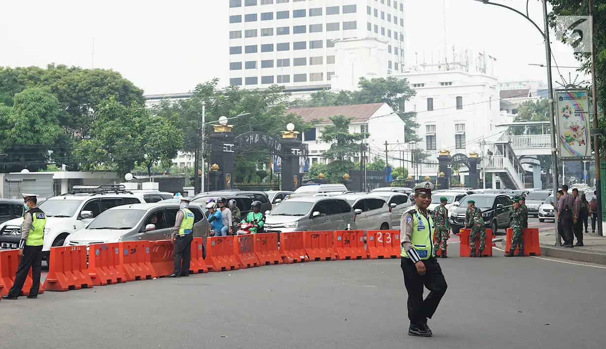 Petugas kepolisian dan TNI berjaga di sekitar lokasi pengalihan arus lalu lintas di Jalan Medan Merdeka Timur, Jakarta, Jumat (14/6/2019). Pengalihan arus dilakukan di sejumlah titik menuju Gedung Mahkamah Konstitusi terkait sidang perdana sengketa Pilpres 2019. (Liputan6.com/Immanuel Antonius)