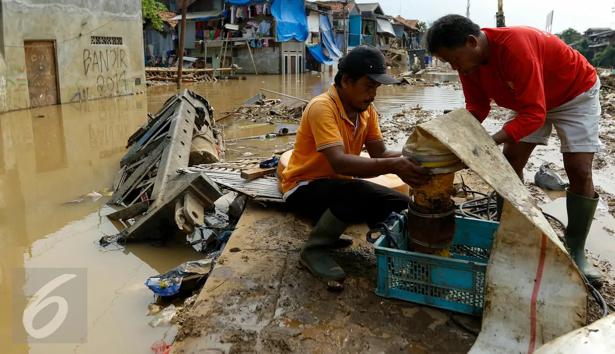 Petugas normalisasi Ciliwung memasang pompa penguras air, Kampung Pulo, Jakarta, Rabu (25/11/2015). Pompa tersebut untuk mempercepat penyurutan banjir di pemukiman Kampung Pulo. (Liputan6.com/Yoppy Renato)