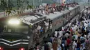 Sejumlah penumpang duduk di atas atap kereta saat mudik menuju kampung halaman untuk merayakan Idul Adha di Lahore, Pakistan, Sabtu (10/8/2019). Umat Islam di seluruh dunia merayakan Idul Adha yang identik dengan tradisi berkurban. (AP Photo/K.M. Chaudary)