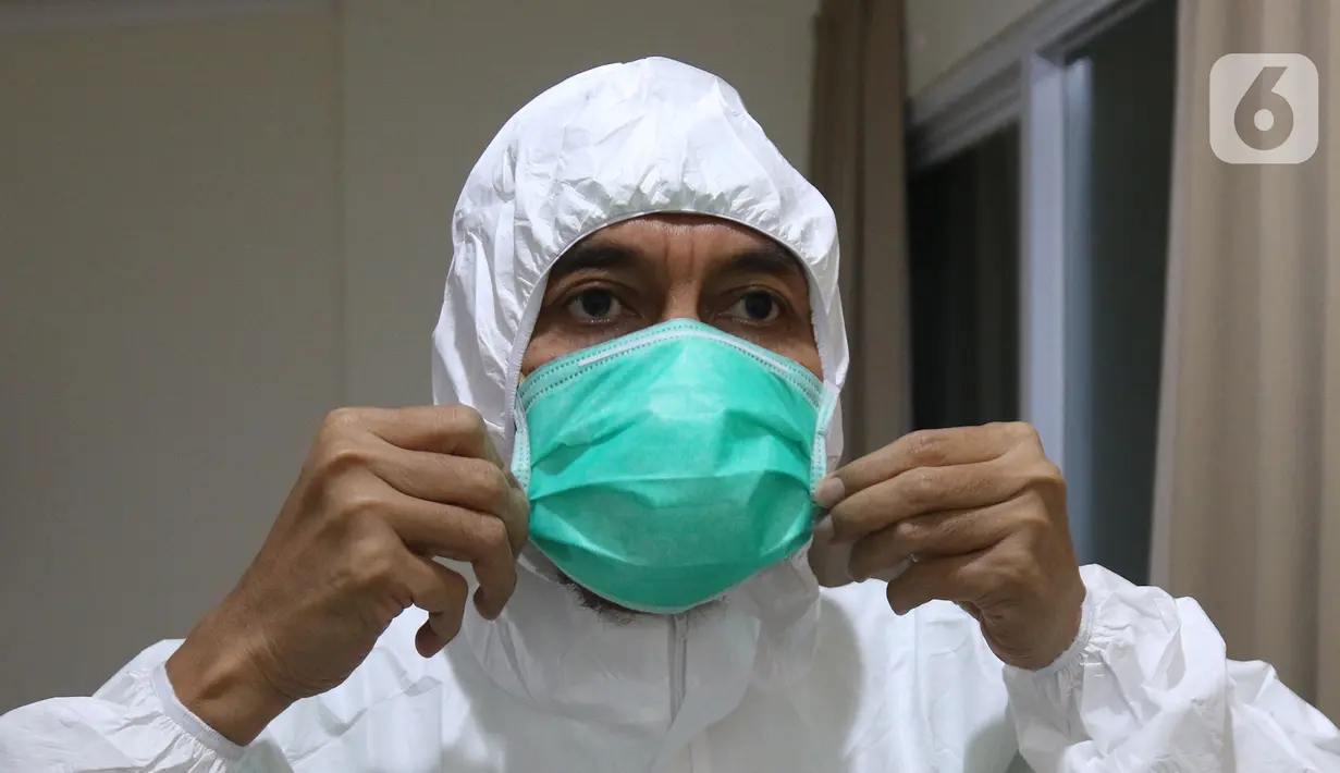 dr Rahmadi Iwan Guntoro, Sp.P merapikan maskernya di Rumah Sakit Haji, Jakarta, Kamis (9/4/2020). Tenaga medis yang menggunakan alat pelindung diri pada tingkatan perlindungan ketiga, yaitu dokter, perawat, dan petugas laboran (laboratorium). (Liputan6.com/Herman Zakharia)