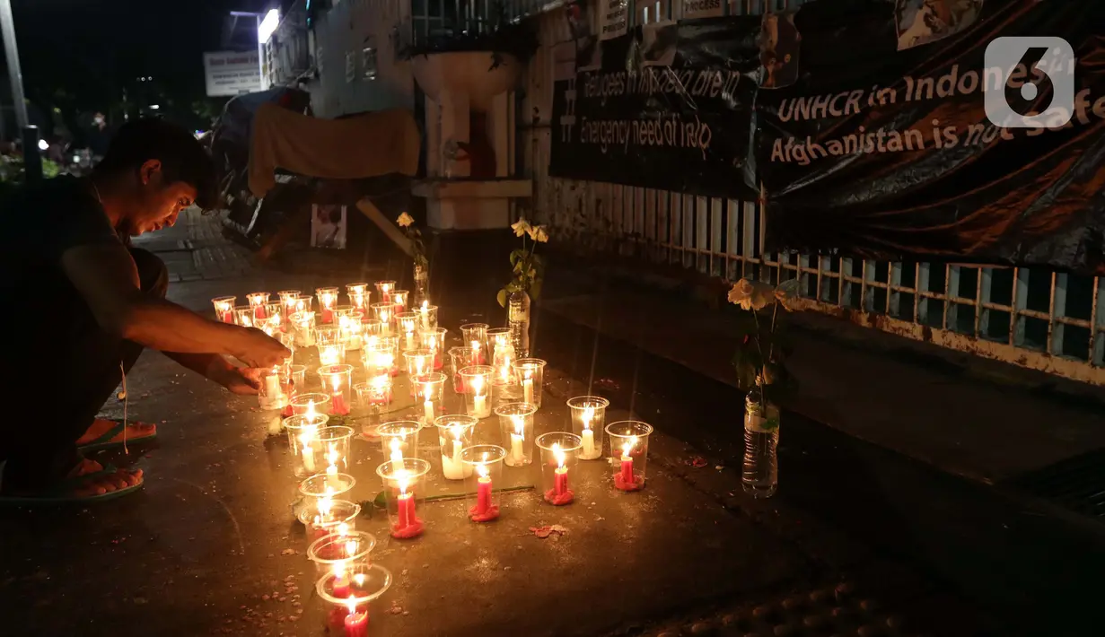 Seorang pencari suaka menyalakan lilin membentuk nama kota di Afghanistan saat aksi keprihatinan yang digelar di depan kantor UNHCR, Jakarta, Selasa (11/5/2021). Mereka prihatin atas peristiwa serangan bom yang menewaskan puluhan siswi di Kabul, Afghanistan. (Liputan6.com/Helmi Fithriansyah)