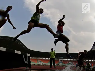 Para pelari melompat saat tampil pada Kejurnas Atletik 2019 nomor 3.000 meter steeplechase senior putra di Stadion Pakansari, Bogor pada Rabu (8/8/2019). Kejurnas Atletik berlangsung dari 3 hingga 7 Agustus. (Bola.com/Peksi Cahyo)