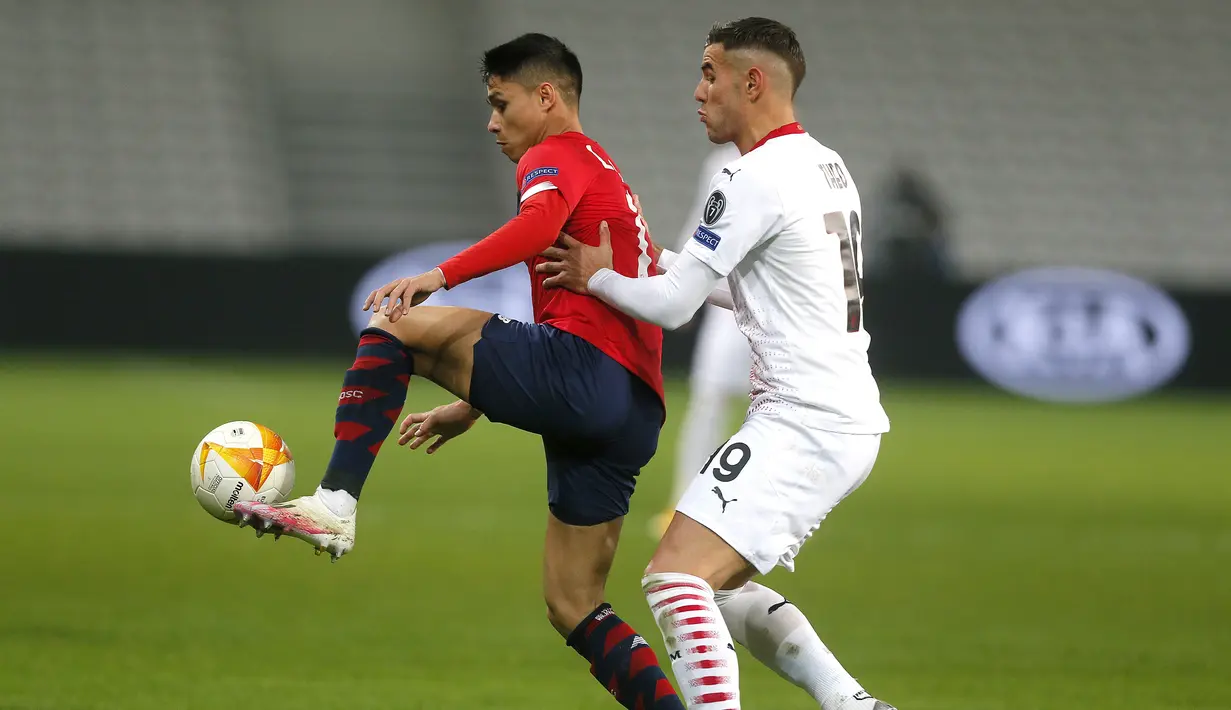 Bek AC Milan, Theo Hernandez berusaha merebut bola dari pemain Lille, Luiz Araujo pada pertandingan lanjutan Grup H Liga Europa di stadion Stade Pierre Mauroy di Villeneuve d'Ascq, Prancis, Kamis (26/11/2020). AC Milan bermain imbang 1-1 atas Lille. (AP Photo/Michel Spingler)