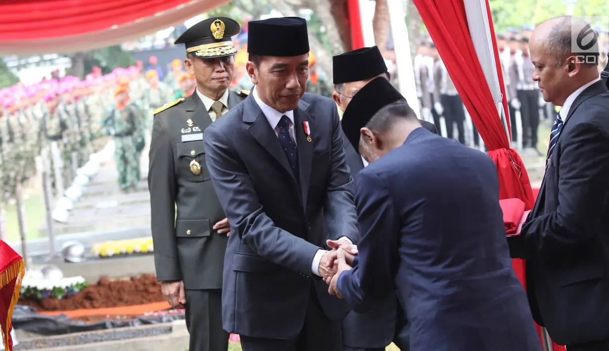 Presiden Joko Widodo bersalaman dengan kedua putra Presiden ke-3 RI Bacharuddin Jusuf Habibie usai meletakan karangan bunga di TMP Kalibata, Jakarta, Kamis (12/9/2019). (Liputan6.com/Herman Zakharia)