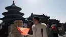 Seorang gadis memegang bendera nasional China saat ia mengunjungi Kuil Surga selama liburan Tahun Baru Imlek di Beijing (20/2). Warga China tengah liburan selama seminggu yang menandai dimulainya Tahun Anjing. (AFP Photo/Nicolas Asfouri)