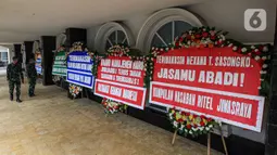 Sejumlah tentara melihat karangan bunga di halaman Kantor PT Asuransi Jiwasraya (Persero), Jakarta, Selasa (15/12/2020). Nasabah Jiwasraya ramai-ramai mengirimkan karangan bunga ke Kantor PT Asuransi Jiwasraya (Persero). (Liputan6.com/Faizal Fanani)