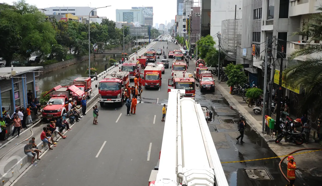 Beberapa kendaraan pemadam bersiaga di sebagian ruas jalan Gajah Mada, Jakarta, Senin (2/1). Arus lalu lintas di sebagian ruas jalan Gajah Mada dialihkan akibat kebakaran yang terjadi di Grand Hotel Paragon. (Liputan6.com/Helmi Fithriansyah)