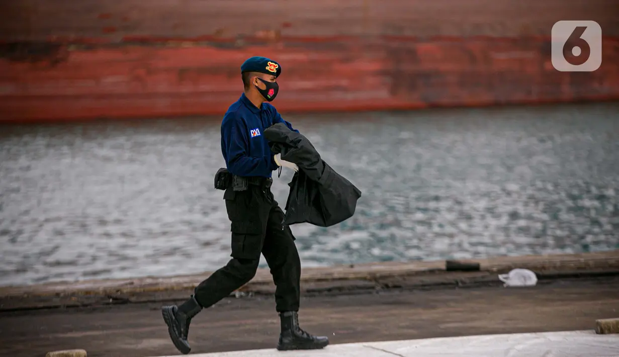 Petugas membawa body part dari kapal Basarnas di JICT II Tanjung Priok, Jakarta, Jumat (15/1/2021). Sebanyak 13 body part penumpang Sriwijaya Air SJ182 berhasil ditemukan dan nantinya akan diidentifikasi di RS Polri Keramat Jati. (Liputan.com/Faizal Fanani)