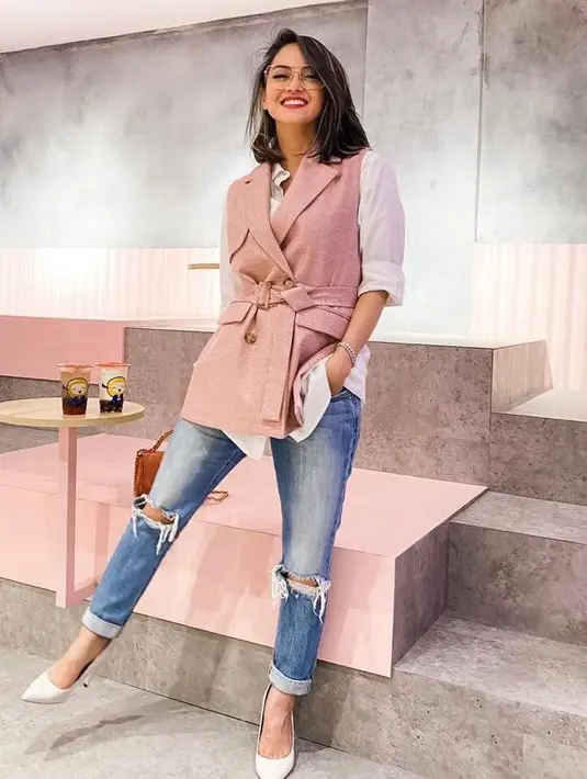 Sementara untuk tampilan semi formal, bisa sontek gaya Ririn Ekawati satu ini. Padukan vest warna pink dengan kemeja warna putih dan ripped jeans. (Instagram/ririnekawati).
