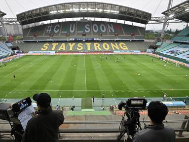 Juru kamera mengambil gambar saat pertandingan Jeonbuk Hyundai Motors melawan Suwon Samsung Blue Wings pada laga K-League di Stadion Jeonju, Korea Selatan, Jumat (8/5/2020). Kembali bergulir di tengah wabah corona, K-League tanpa penonton. (AFP/Jung Yeon-Je)