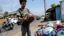 Pedagang sedang membersihkan helm dagangannya di kawasan Kali Malang, Jakarta, Selasa (14/7/2015). Meskipun mendekati hari lebaran mereka tetap berjualan aksesoris. (Liputan6.com/Faizal Fanani)