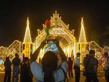 Salah satu pemgunjung sedang mendokumentasikan keindahan di Charming Chiang Mai Flower Festival pada Kamis (11/12/2025). (Bola.com/Bagaskara Lazuardi)