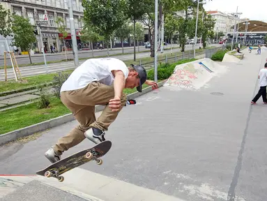 Seorang pria bermain papan luncur atau skateboard di sebuah taman olahraga jalanan di Wina, Austria, Rabu (8/7/2020). Sejumlah orang di Wina pergi ke taman olahraga jalanan untuk melakukan olahraga luar ruangan setelah pembatasan COVID-19 dicabut. (Xinhua/Georges Schneider)