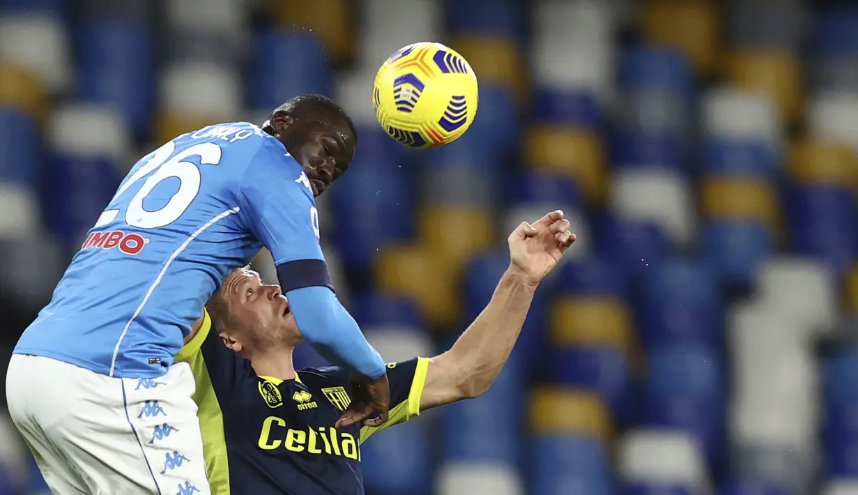 Bek Napoli, Kalidou Koulibaly (kiri) berduel udara dengan striker Parma, Andreas Cornelius dalam laga lanjutan Liga Italia 2020/21 pekan ke-20 di Diego Armando Maradona Stadium, Minggu (31/1/2021). Napoli menang 2-0 atas Parma. (LaPresse via AP/Alessandro Garofalo)