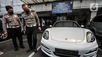 Dirlantas Polda Metro Jaya Kombes Pol Sambodo Purnomo meninjau mobil Porsche saat disita di Kantor Ditlantas Polda Metro Jaya, Jakarta, Senin (26/4/2021). (merdeka.com/Iqbal S. Nugroho)