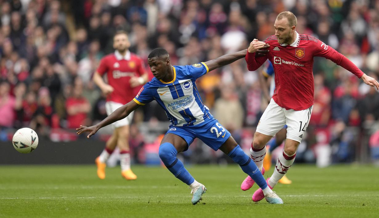Pemain Brighton, Moises Caicedo (kiri) berebut bola dengan pemain Manchester United, Christian Eriksen pada laga semifinal Piala FA 2022/2023 di Stadion Wembley, London, Minggu (23/04/2023). Laga dimenangkan oleh MU dengan skor 7-6 melalui babak adu penalti. (AP Photo/Kirsty Wigglesworth)