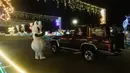 <p>Pengunjung naik kendaraan mereka ke "The Candy Cane Lane Holiday Light Drive Through Experience" yang menampilkan hanya kurang dari satu kilometer lampu Natal dan dekorasi di atap Pusat Perbelanjaan Pavillion di Durban, Afrika Selatan (14/12/2021). (AFP/Rajesh Jayantilal)</p>