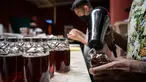 Seorang karyawan menyegel sebotol minuman ExtraGineca, minuman yang terinspirasi oleh vaksin virus corona Covid-19, di sebuah bar koktail di George Town di pulau Penang, Malaysia (8/9/2021). (AFP/Mohd Rasfan)
