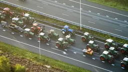 Pemandangan dari udara memperlihatkan traktor memblokir jalan di De Bilt, Belanda, Rabu (16/10/2019). Para petani mengkritik kebijakan pemerintah untuk memerangi perubahan iklim. (Jerry Lampen/ANP/AFP)