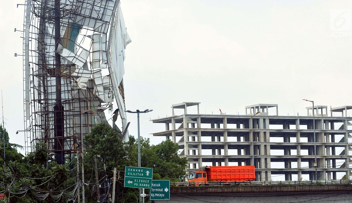 Sebuah papan reklame di kawasan Terminal Kampung Melayu hampir roboh, Jakarta, Senin (2/10). Hujan deras disertai angin kencang yang mengguyur Ibu Kota kemarin membuat papan reklame ini hampir roboh.(Liputan6.com/Helmi Afandi)