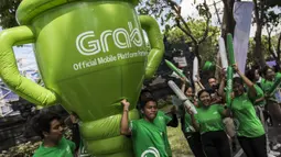 Sejumlah mitra dari Grab membawa balon raksasa saat pawai obor Asian Games XVIII di Denpasar, Bali, Selasa (24/7/2018). Sebanyak 53 kota di Indonesia akan dilalui oleh obor Asian Games. (Bola.com/Vitalis Yogi Trisna)