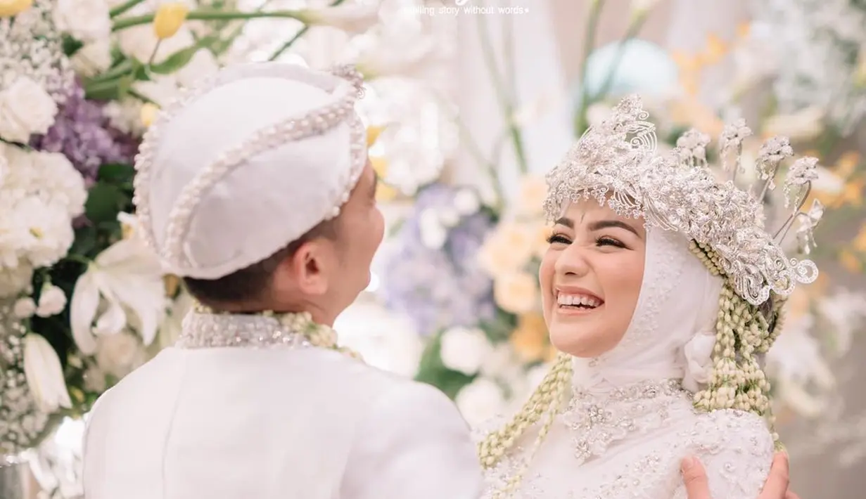 Melihat kembali potret pernikahan keduanya yang teduh memesona. Citra Kirana tampil sangat cantik dibalut kebaya pernikahan brokat berwarna putih, sedang Rezky Aditya dengan jas putih dan penutup kepala yang serasi, keduanya sempurna memancarkan aura pengantin yang luar biasa serasi. Foto: Instagram.
