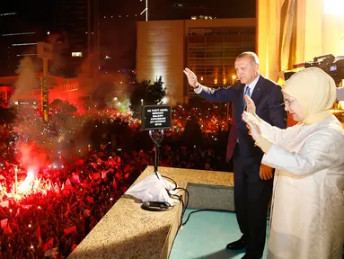 Presiden Turki Recep Tayyip Erdogan dan istri, Emine menyapa pendukung Partai Keadilan dan Pembangunan (AKP) di Ankara, Turki, Senin (25/6). Erdogan kembali memenangkan pemilu presiden di Turki. (Presidency Press Service via AP, Pool)