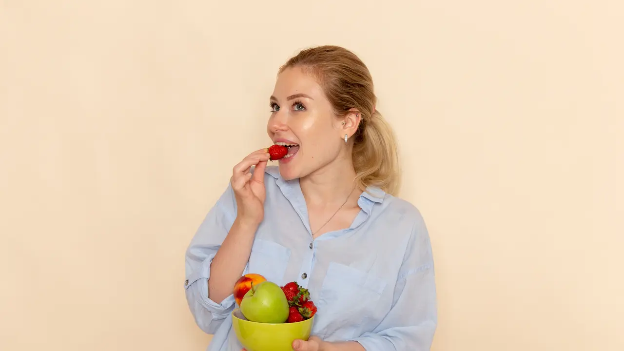 Seorang perempuan sedang makan buah-buahan (Foto Dok: Freepik/KamranAydinov)