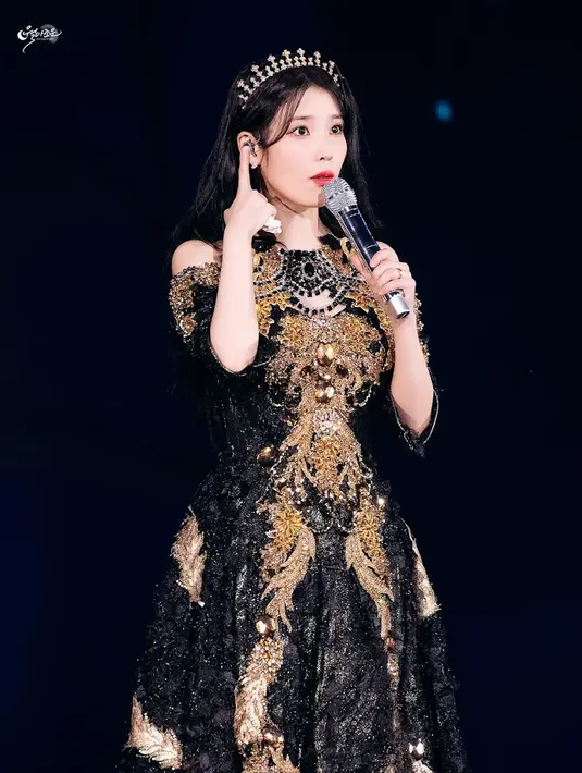 <p>Balutan gaun hitam emas ini bikin IU tampil elegan. (Foto: via Koreaboo)</p>