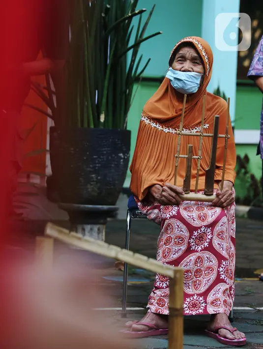 Seorang lansia mengikuti latihan angklung di Rumah Rehabilitasi Psikososial Dinas Sosial Kota Tangerang, Banten, Rabu (19/5/2021). Kegiatan berlatih angklung bagi lansia tersebut guna mengisi waktu luang sekaligus melatih motorik, auditori, dan sensorik para lansia. (Liputan6.com/Angga Yuniar)