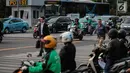 Penyeberang jalan melewati pengendara sepeda motor yang berhenti di lampu merah Jalan MH Thamrin, Jakarta, Kamis (4/10). Uji coba sistem tilang elektronik berlaku mulai 1 Oktober 2018. (Liputan6.com/Faizal Fanani)