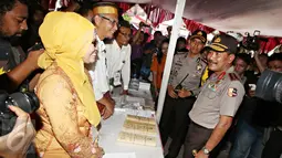 Kapolri Jendral Badrodin Haiti berbincang dengan panitia TPS Kampung Pilkada RW 03, Depok, Jawa Barat, Rabu (9/12). Kapolri turun langsung ke lapangan untuk memastikan kelancaran Pilkada. (Liputan6.com/Immanuel Antonius)