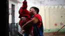 Noelia Garella menggendong seorang murid  di TK Jeromito, Cordoba, Argentina (24/10). Dengan kondisi yang dideritanya Noelia Garella tetap semangat mengajari para murid TK di Argentina.  (AFP Photo/Diego Lima)