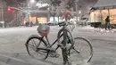 Sebuah sepeda tertutup salju terlihat di Manhattan, New York, Kamis (15/11). Layanan Cuaca Nasional memprediksi hujan salju pertama pada awal musim dingin itu akan mencapai ketebalan 2-4 inci. (Angela Weiss / AFP)