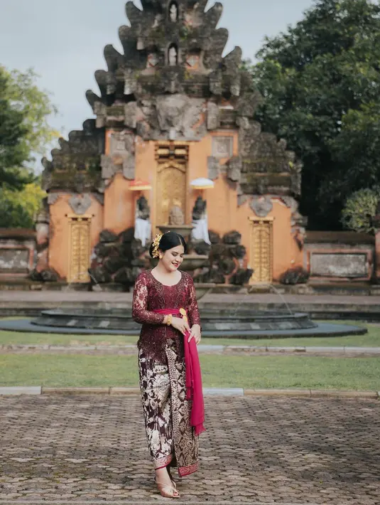 Kahiyang Ayu juga pernah terlihat mengenakan kebaya Bali. Kebaya berwarna merah keunguan wine ini, dipadu Kahiyang dengan kain Bali dan selendang merah yang senada. Kahiyang tampak semakin ayu dengan aksesori emas, seperti hair-piece, bros, anting, dan gelangnya. [Foto: Instagram/ayanggkahiyang]