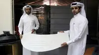 Insinyur mesin Abdullah Mojeb Aldar (kiri) dan Fahad al-Musalam tampak membawa model stadion yang dibuat menggunakan mesin cetak 3D (Reuters)