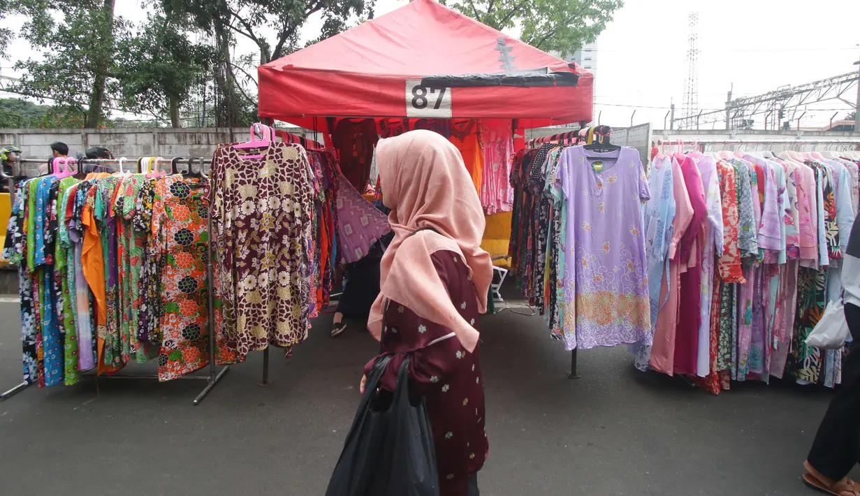 Calon pembeli melihat dagangan PKL di Tanah Abang, Jakarta, Kamis (5/7). Ombudsman RI Perwakilan Jakarta Raya mengingatkan Pemprov DKI, hanya PKL yang sudah divalidasi nantinya boleh berjualan di "skybridge" Tanah Abang. (Liputan6.com/Angga Yuniar)