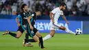 Pemain Al Jazira, Ali Mabkhout saat menendang bola dari kawalan dua pemain Real Madrid pada semifinal Piala Dunia Antarklub di Syekh Zayed Sports City Stadium, (14/12). Madrid menang 2-1 atas Al Jazira. (AP Photo/Hassan Ammar)