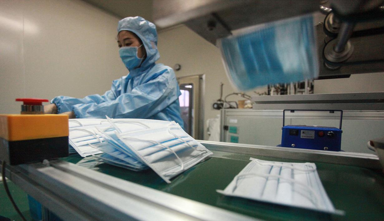 Pekerja memproduksi masker di sebuah pabrik di Yangzhou, Provinsi Jiangsu, China, Senin (27/1/2020). Masker tersebut diproduksi untuk mendukung pasokan bahan medis saat wabah virus corona melanda China. (STR/AFP)