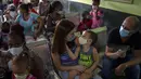 Orang tua menunggu bersama anak mereka untuk menerima dosis vaksin COVID-19 Soberana-02 di sebuah klinik di Havana, Kuba, Kamis (17/9/2021). Pemerintah Kuba memulai vaksinasi Covid-19 bagi anak-anak berusia 2 tahun dengan vaksin buatan dalam negeri. (AP Photo/Ramon Espinosa)