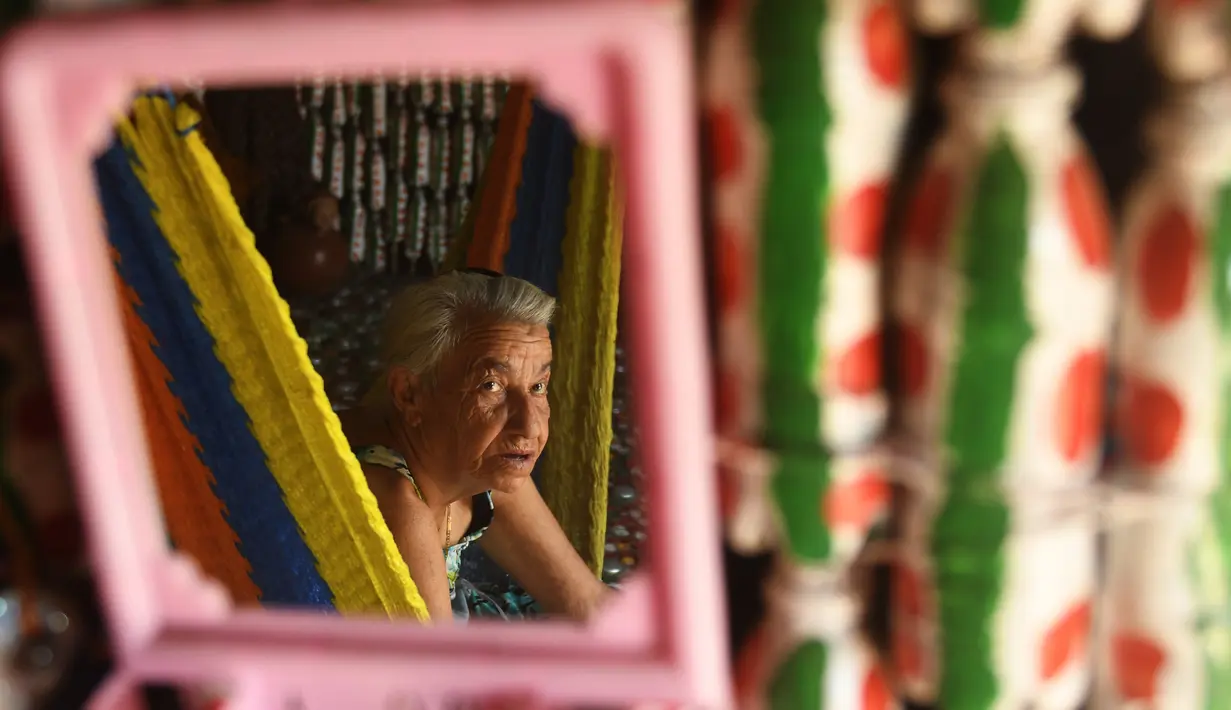 Maria Ponce (86) terlihat di cermin yang menghiasi rumahnya yang terbuat dari botol plastik bekas di Desa El Borbollon, El Transito, San Salvador, El Salvador 14 Maret 2017. (AFP Photo/Marvin Recinos)